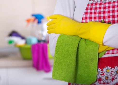 Domestic cleaner tidying a kitchen in Fulham